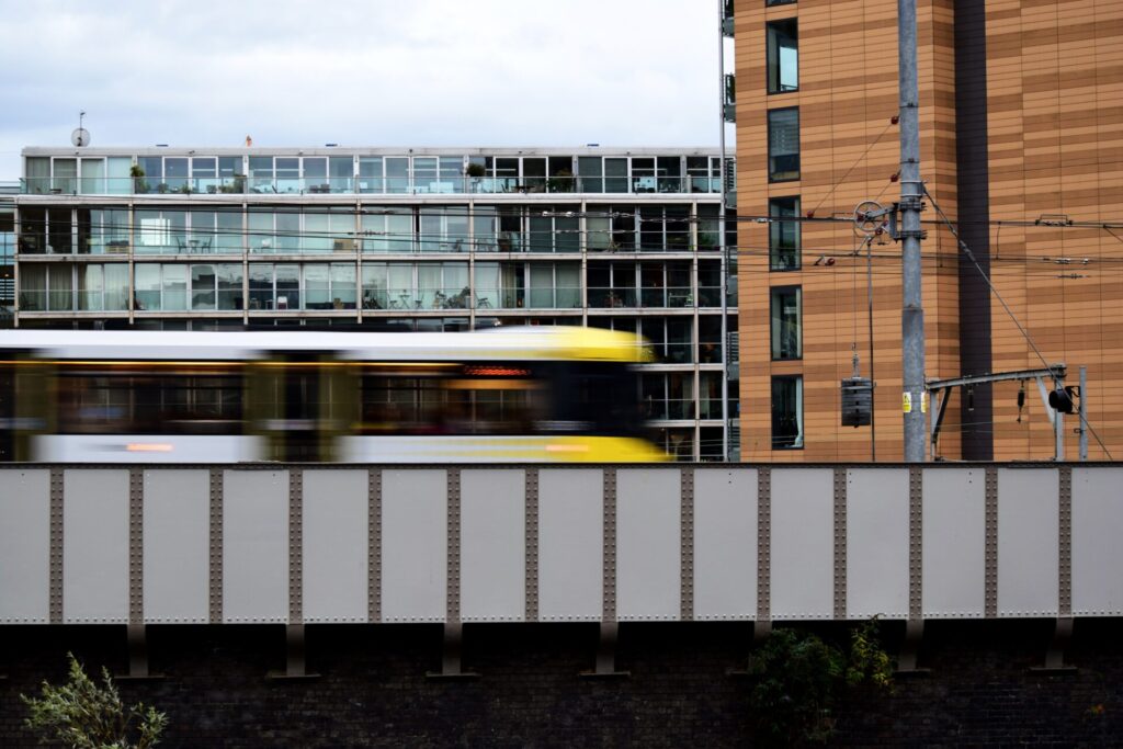 A train carriage moving quickly, blurred against a city background
