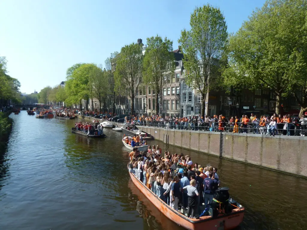 Canal Boats and crows in Amsterdam on Kings Day