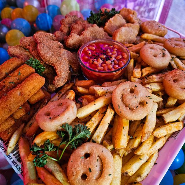 A platter of smiley faces, turkey dinosaurs, chicken nuggets, chips, and fish fingers