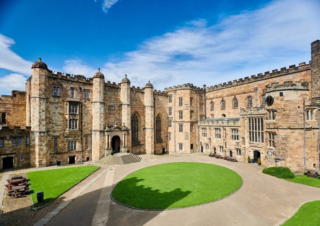 A view of Durham Castle from its courtyard on a sunny day.