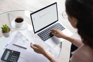 Someone calculating expenses on a laptop.