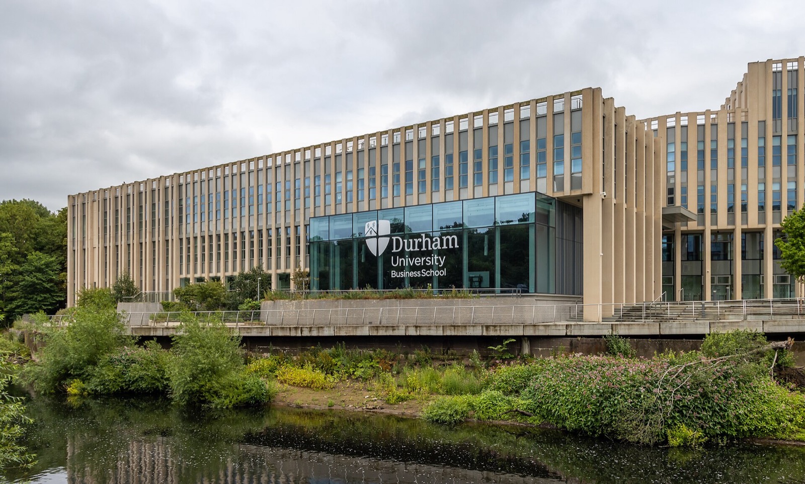 Durham University Business School building beside greenery and a pond