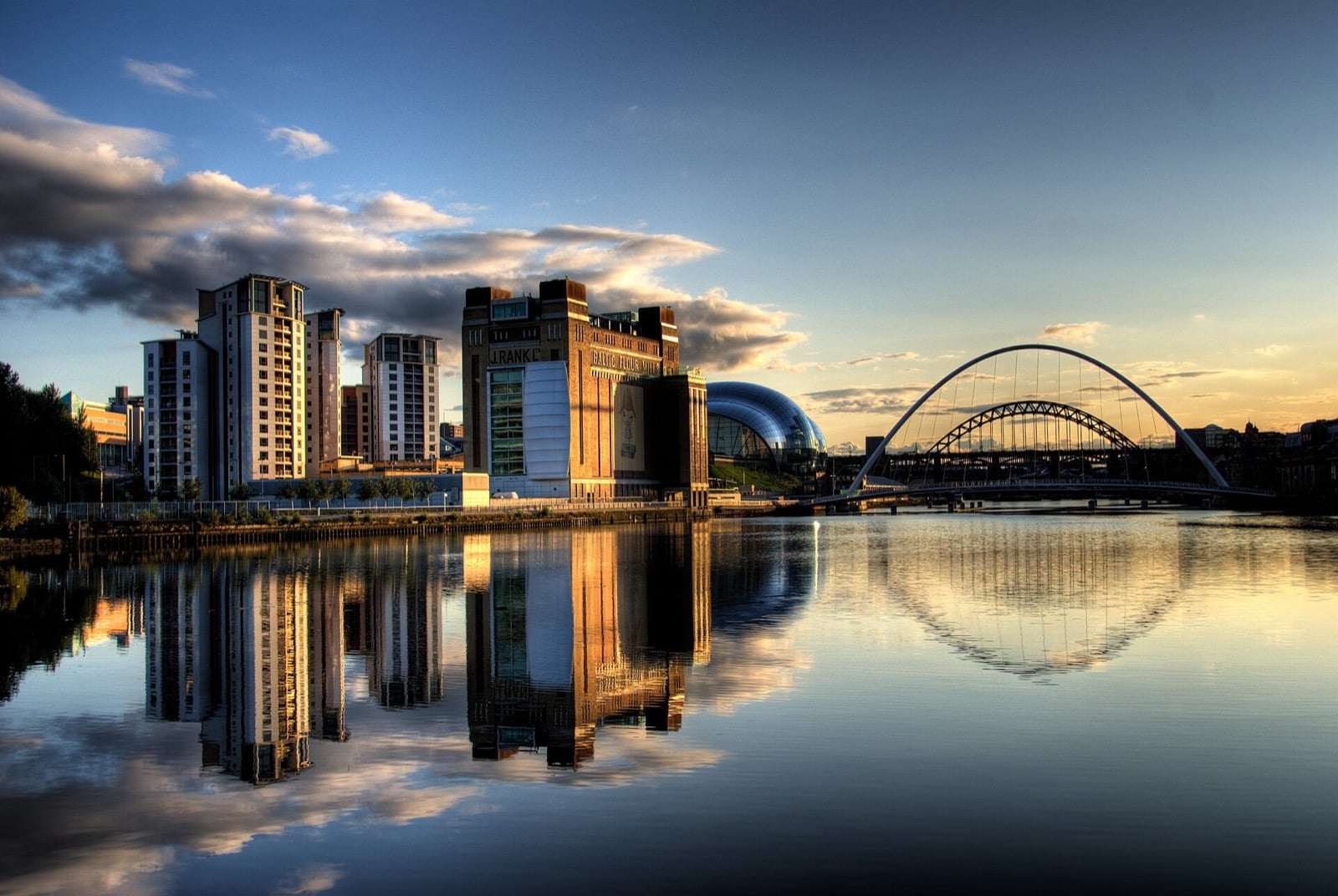 Newcastle Quayside at sunrise with the Gateshead Millennium Bridge reflected in the River Tyne