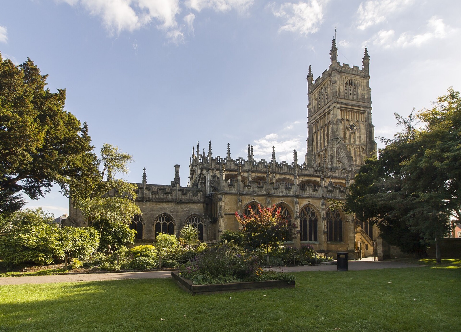 The Perpendicular Gothic church of St John the Baptist in Cirencester under a blue sky