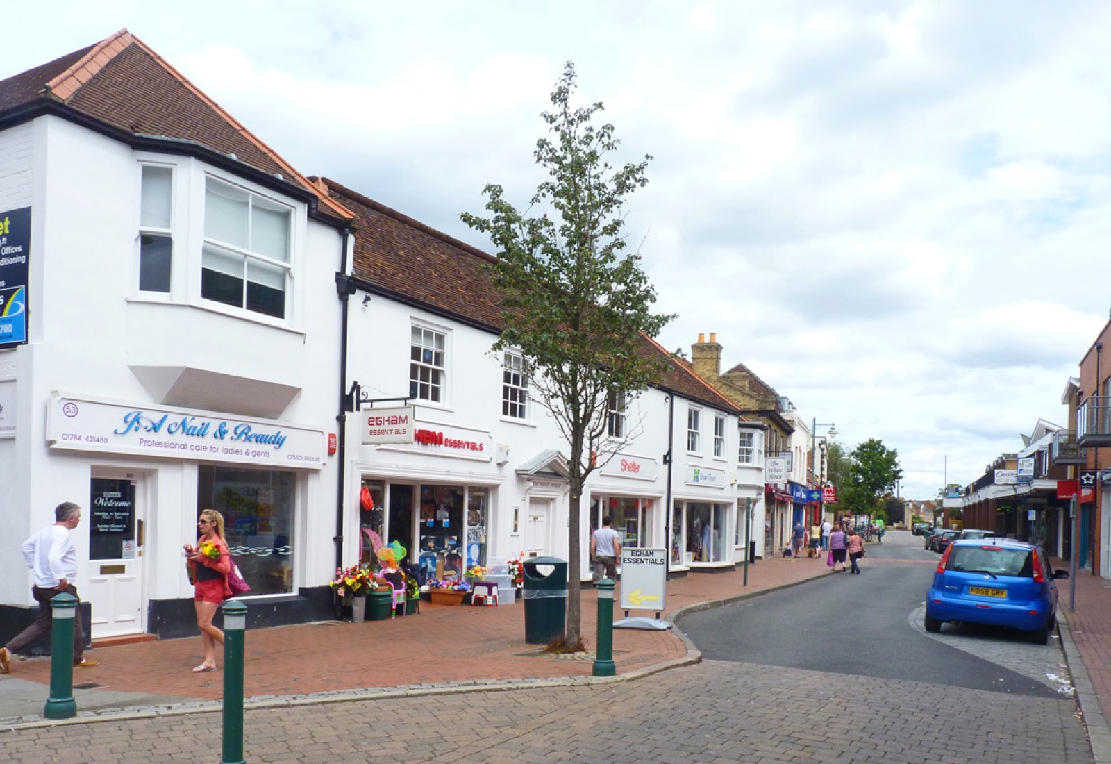 Shops along the High Street in Egham, Surrey, on a sunny day