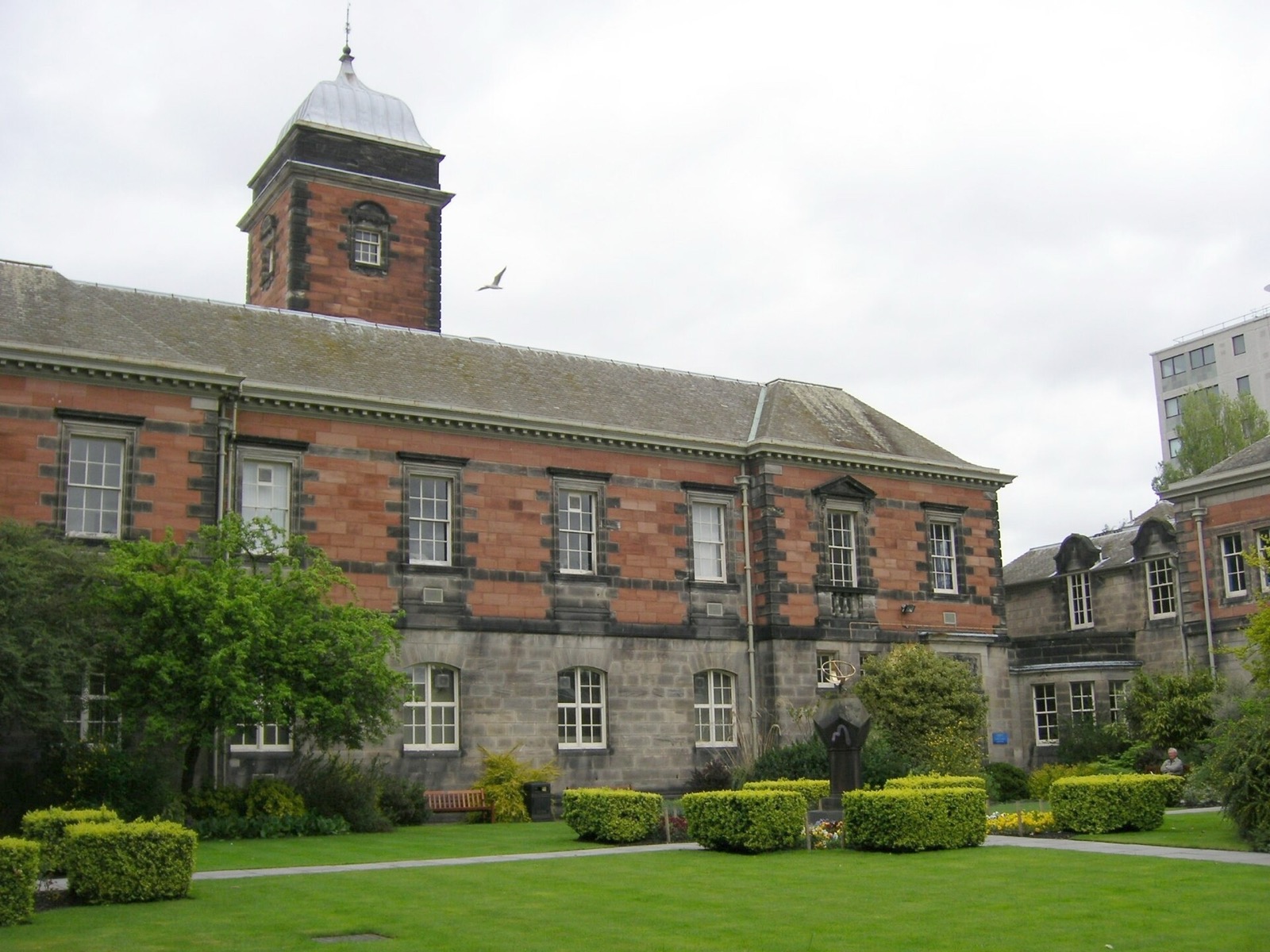 Historic red sandstone University of Dundee building and lawn
