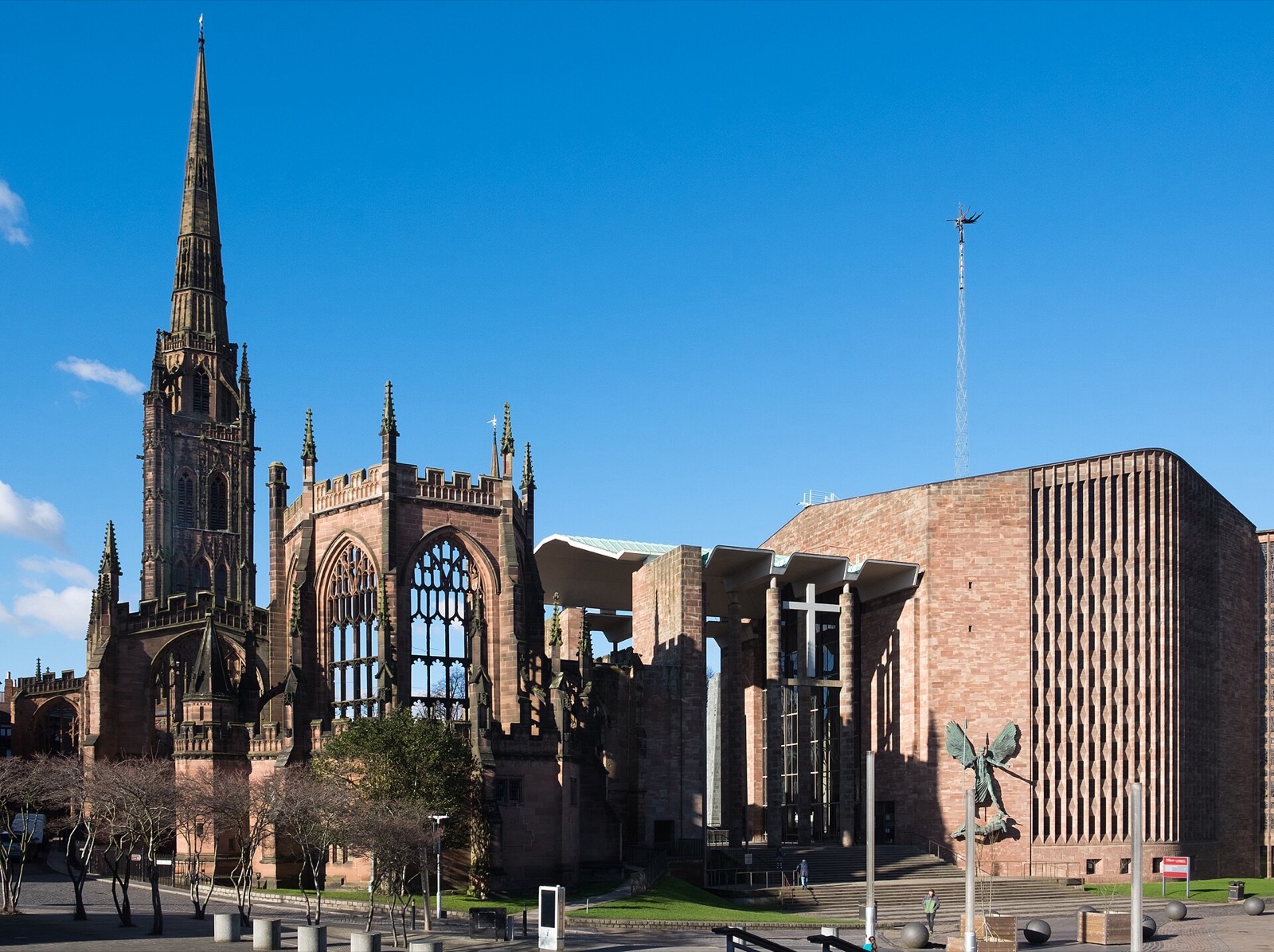 Coventry Cathedral, old and new, side by side under a clear blue sky