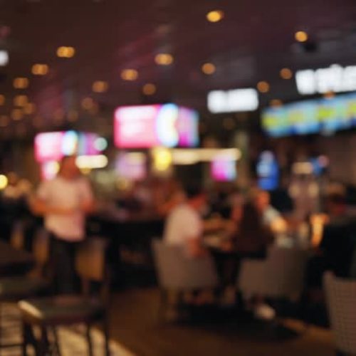 Defocused group of people handing over answers during a bar quiz game at pub. Slow motion blurry footage